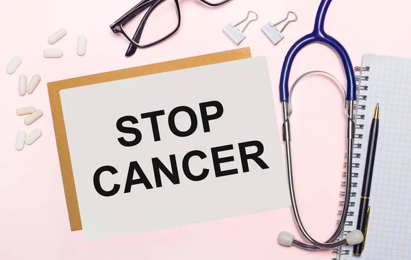 분홍색 배경에는 청진기 안경테의 Stop Cancer 이라는 글자가 이있다 위에서 — 스톡 사진