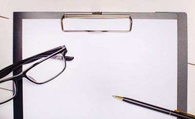 Hafif ahşap arka planda, gözlükler, bir kalem ve bir sayfa kağıt üzerinde metin eklemek için bir yer. Şablon. İş konsepti