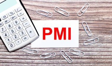 Tahta bir arka planda, beyaz bir hesap makinesi, beyaz ataçlar ve PMI Proje Yönetim Enstitüsü yazılı beyaz bir kart. Yukarıdan görüntüle.