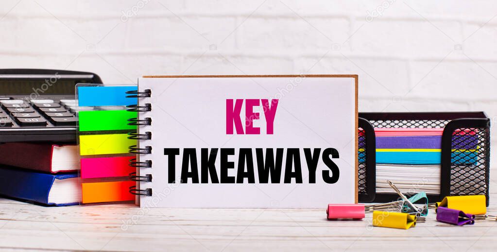 On a light wooden background, a calculator, multi-colored sticks and a notebook with the text KEY TAKEAWAYS. Business concept