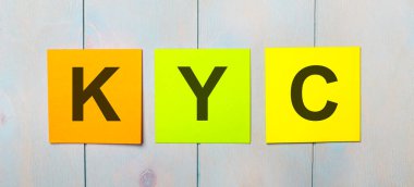 Açık mavi ahşap arka planda KYC CUSTOMER bilir üç renkli çıkartma