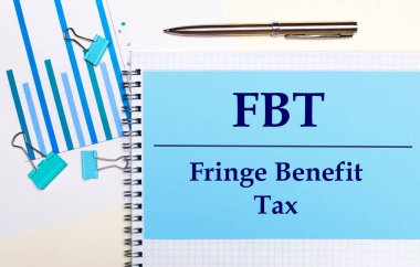 Açık arkaplanda - açık mavi diyagramlar, ataçlar ve FBT Fringe Sigorta Vergisi yazılı bir kağıt. Yukarıdan bak. İş konsepti