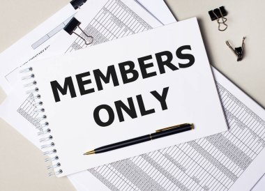 Masaüstünde dokümanlar, kalem, siyah ataçlar ve sadece metin üyeleri olan bir defter var. İş konsepti