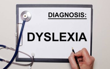 Hafif bir arkaplanda, bir steteskop ve üzerine DYSLEXIA yazan bir kağıt. Tıbbi konsept