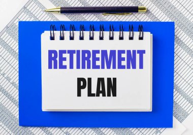 Masaüstündeki raporların arka planında mavi bir not defteri var. İçinde bir kalem ve beyaz bir defter var. Yazılı bir not defteri. İş konsepti