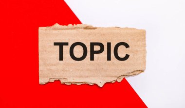 Beyaz ve kırmızı zemin üzerinde, kahverengi yırtık karton TOPIC metni ile