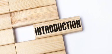 Hafif bir arkaplanda, tahta bloklar ve metin INTRODUCON. Üst görünümü kapat.