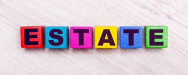 On a light wooden background, multi-colored wooden cubes with the text ESTATE.