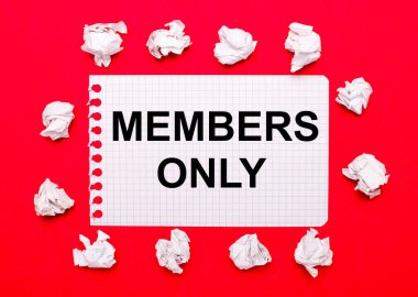 On a bright red background, white crumpled sheets of paper and a sheet of paper with the text MEMBERS ONLY