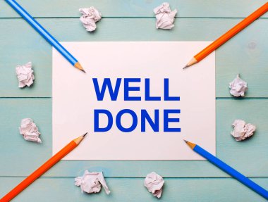 On a blue background - black and orange pencils, white crumpled sheets of paper and a white sheet of paper with the text WELL DONE