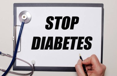 Hafif bir arkaplanda steteskop ve üzerine STOP DIABETES yazan bir kağıt var. Tıbbi konsept
