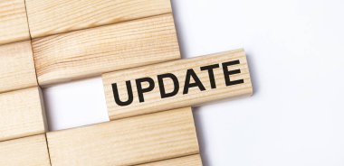 Hafif arkaplanda, yazı UPDATE ile ahşap bloklar. Üst görünümü kapat.