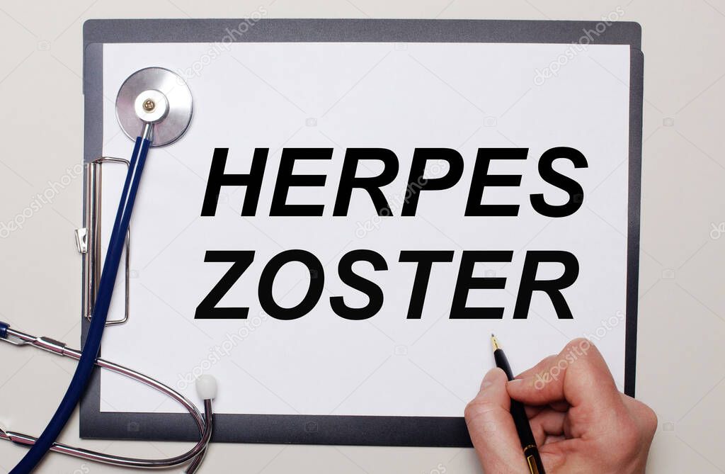 On a light background, a stethoscope and a sheet of paper, on which a man writes HERPES ZOSTER. Medical concept