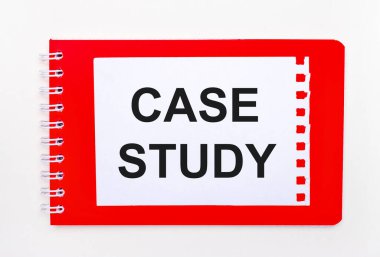 Beyaz arka planda, spiral üzerinde parlak kırmızı bir defter. Üzerinde 