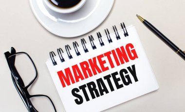 Bardaklar, beyaz bir fincan kahve, beyaz bir defter, üzerinde 