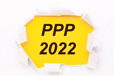 Yırtık beyaz kağıt, PPP 2022 metni ile parlak sarı bir zemin üzerinde yatar
