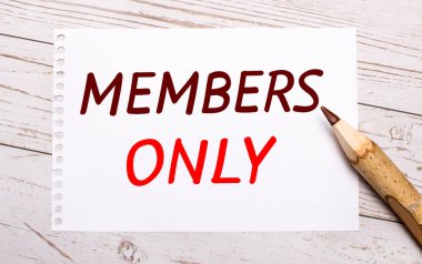 Hafif ahşap bir arka planda, renkli bir kalem ve üzerinde sadece metin üyeleri olan beyaz bir sayfa.