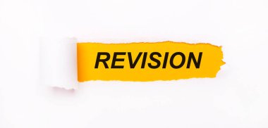 Parlak sarı bir zemin üzerinde, yırtık çizgili beyaz bir kağıt ve yazıt REVISION