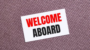 Kahverengi arkaplanda beyaz dikdörtgen bir kart var. Üzerinde 