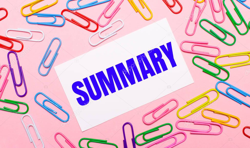 On a light pink background, colorful bright paper clips and a white card with the text SUMMARY
