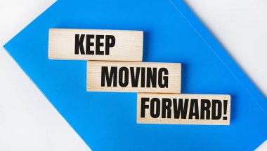 Açık gri arka planda mavi bir defter var. Üzerinde 