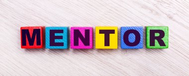 Açık ahşap bir arka planda, çok renkli ahşap küplerin üzerinde.