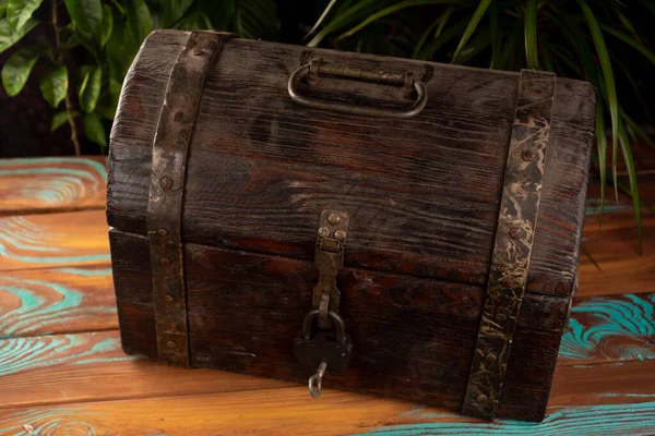 old pirate chest with a lock close-up on a background of plants