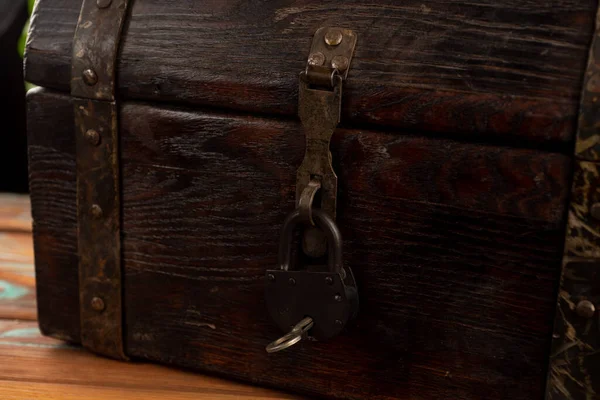 old pirate chest with a lock close-up on a background of plants