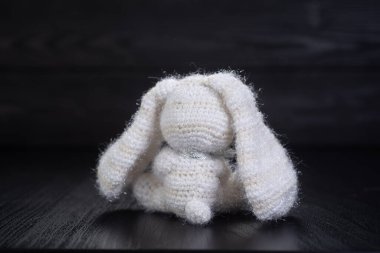 Örgü beyaz kabarık tavşan siyah arkaplanda