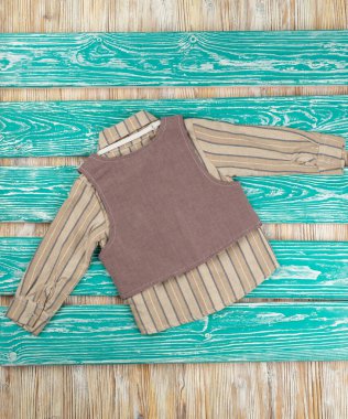 Tahta arka planda bebek resmi olan sevimli kahverengi takım elbise.