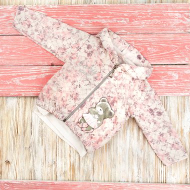 Tahta bir masada uzanan küçük bir kız için yıldırım üstünde spor kıyafeti.