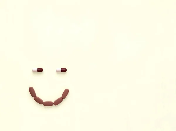 Pigułki Kapsułki Postaci Uśmiechu Beżowym Tle — Zdjęcie stockowe