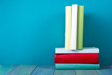Book in library on blue wooden shelf. Education background with copy space for text. Toned photo