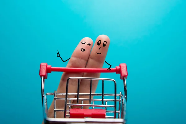 Lustige Finger beim Einkaufen im Supermarkt mit rotem Einkaufswagen auf blauem Hintergrund — Stockfoto