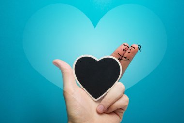 Painted happy fingers smiley in love with blackboard heart