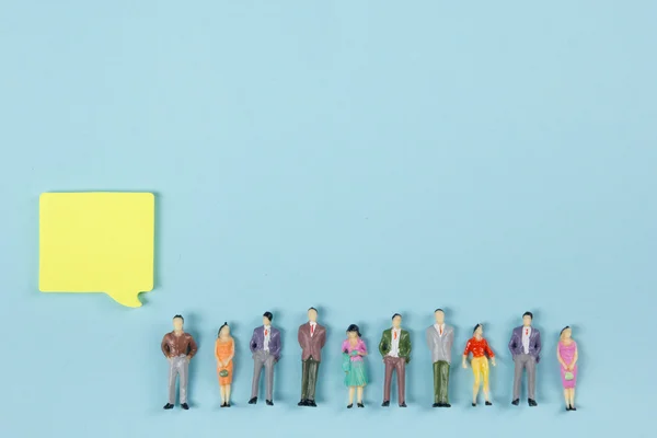 Concetto immobiliare. Bolle di discorso vuote e figure giocattolo della gente Costruzione, costruzione. Casa modello di carta con chiave su sfondo blu. Vista dall'alto. Copia spazio per testo . — Foto Stock