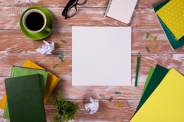 Mesa de escritório com suprimentos, bloco de notas em branco branco, copo, caneta, pc, papel amassado, flor no fundo de madeira. Vista superior — Fotografia de Stock