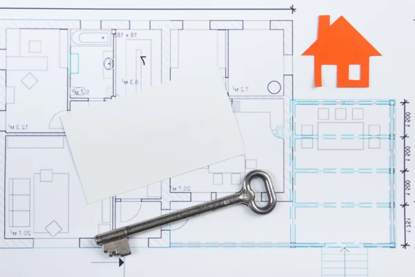 Architectural project, blueprints, key with house figure and blank business card on wooden background. Real Estate Concept. Top view. Royalty Free Stock Photos