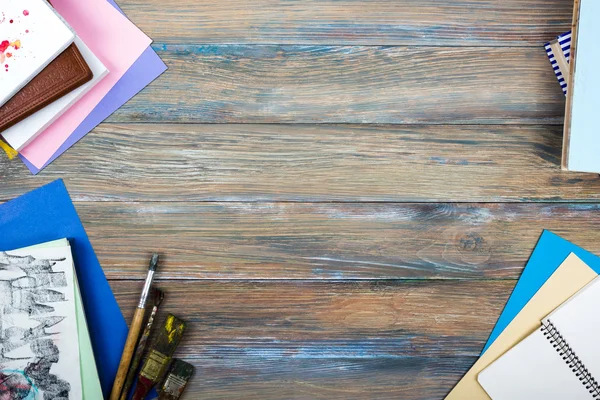 Escritorio de mesa de oficina con suministros, bloc de notas blanco, taza, pluma, PC, papel arrugado, flor sobre fondo de madera. Vista superior — Foto de Stock