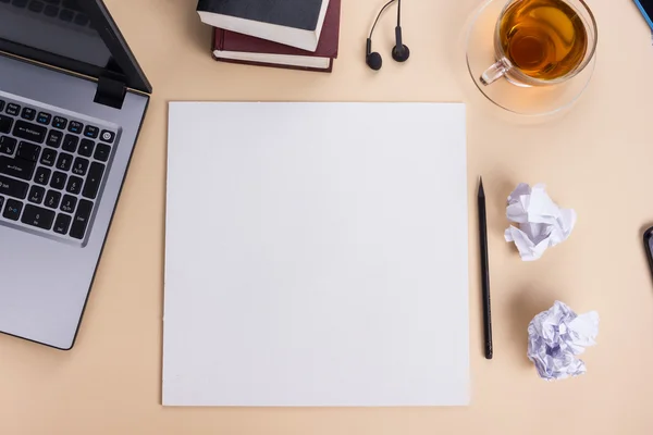 Bureau bureau avec ensemble de fournitures colorées, bloc-notes blanc, tasse, stylo, pc, papier froissé, fleur sur fond beige. Vue du dessus et espace de copie pour le texte — Photo