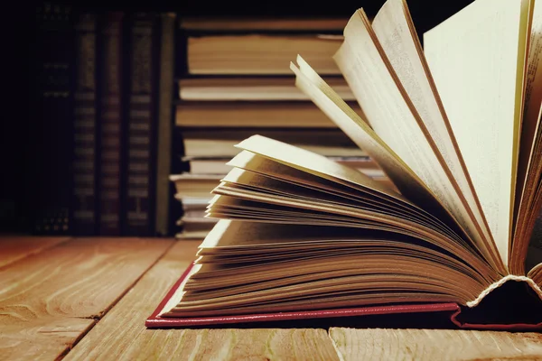 Buch in der Bibliothek auf einem Holzregal geöffnet. Bildungshintergrund mit Kopierraum für Text. getöntes Foto — Stockfoto