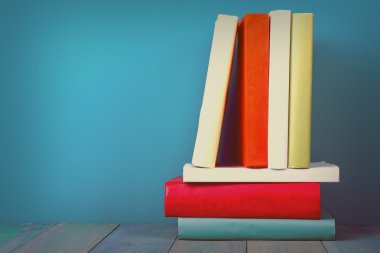Book in library on blue wooden shelf. Education background with copy space for text. Toned photo