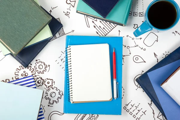 Birou birou de masă cu consumabile albastre, alb gol notă pad, ceașcă, stilou, PC, hârtie sfărâmată, flori pe fundal din lemn. Privire de sus — Fotografie, imagine de stoc