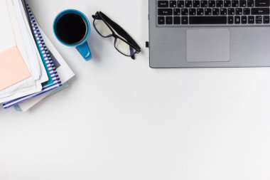 Ofis tablo büro malzemeleri, boş not defteri, Kupası, kalem, pc, buruşuk Kağıt, beyaz arka plan üzerinde çiçek. Üstten görünüm