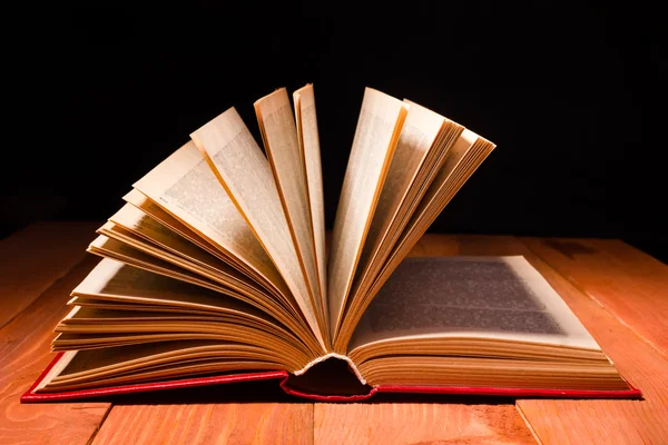 Buch in der Bibliothek auf einem Holzregal geöffnet. Bildungshintergrund mit Kopierraum für Text — Stockfoto