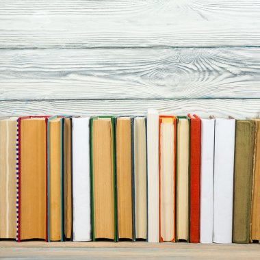 Kütüphanede grunge ahşap masa masa rafkitaplar. Okul arka planına geri dön, reklam metniniz için kopya alanı. Etiketsiz eski ciltli kitap, boş omurga