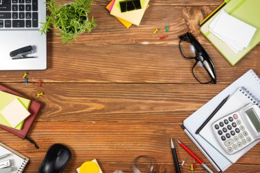 Renkli malzemeleri seti ile Ofis masa masası, beyaz boş not defteri, fincan, kalem, pc, buruşuk kağıt, ahşap arka plan üzerinde çiçek. Reklam metni için en iyi görünüm ve kopyalama alanı