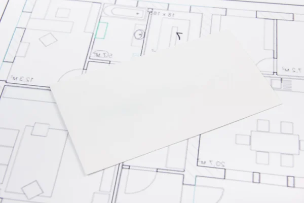 Architectural project, blueprints, key with house figure and blank business card on wooden background. Real Estate Concept. Top view.