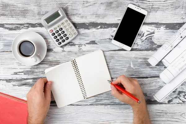 Escritorio de mesa de oficina con conjunto de suministros de colores, bloc de notas blanco, taza, pluma, PC, papel arrugado, flor sobre fondo azul. Vista superior y espacio de copia para texto — Foto de Stock