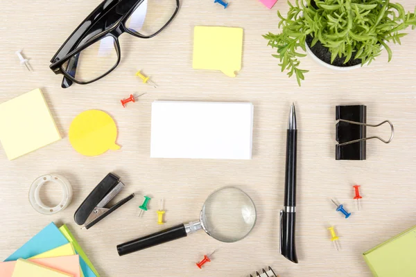 ホワイト・ブランクの名刺。カラフルな電源、カップ、ペン、鉛筆、花、ノート、ベージュの背景にカードのセットとオフィステーブルデスク。広告テキストのトップ表示とコピースペース — ストック写真